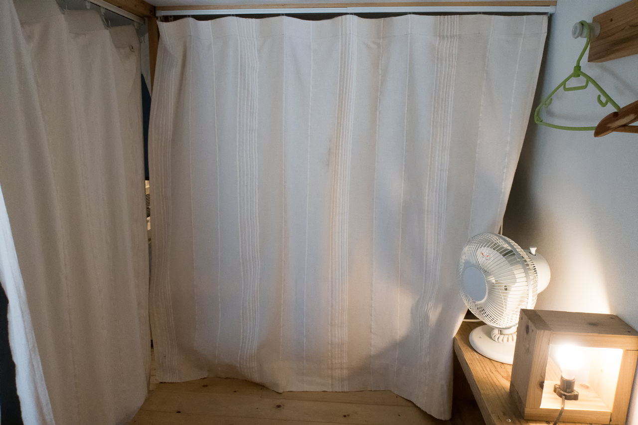 東京ひかりゲストハウスのベッドの仕切りカーテン